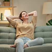 Woman in tan shirt relaxing on couch