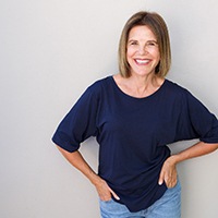 Woman in navy shirt smiling with hands on her hips