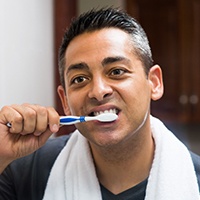 Man brushing his dental implants in Asheville