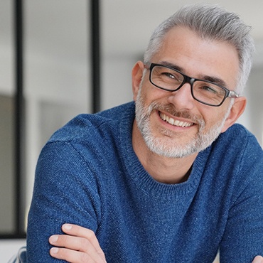 Man in blue shirt leaning forward and smiling
