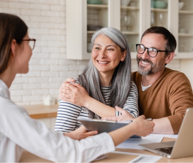 Couple speaking to dentist at a desk
