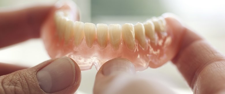 Man smiling with dentures wearing glasses 