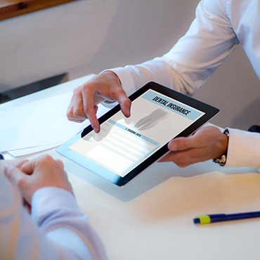 Patient looking at dental insurance form on tablet