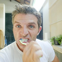 Man brushing dental implants in Asheville