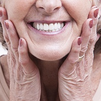 Closeup of smiling woman with mini dental implants in Asheville