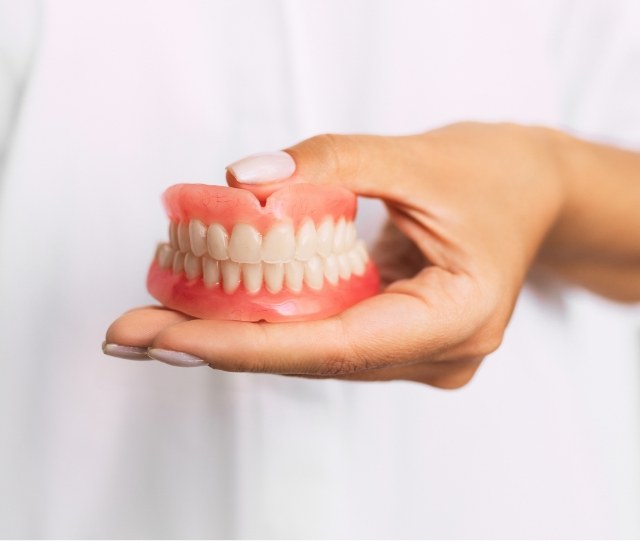 Close up of dentist holding full dentures