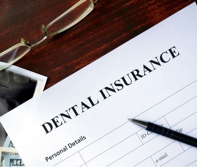 Dental insurance form with pen and glasses