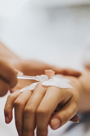 Close-up of IV being inserted into patient’s hand