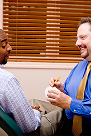 Doctor White smiling and speaking with patient about sleep apnea treatment
