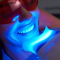 Woman getting teeth whitening treatment