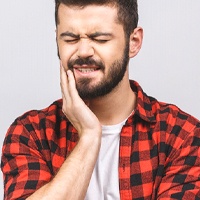Young man with toothache due to impacted wisdom teeth